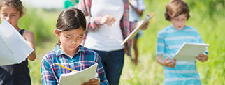 Young people taking notes outdoors