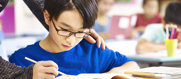 Pupil in class being helped by teacher