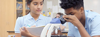 Student looking in microscope in science class