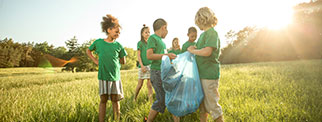Young people picking rubbish outdoors.